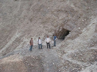 Archaeologists Kevin Vaugh, Moises Linares Grados, and company standing in front of a modern mine near the Ingenio Valley.